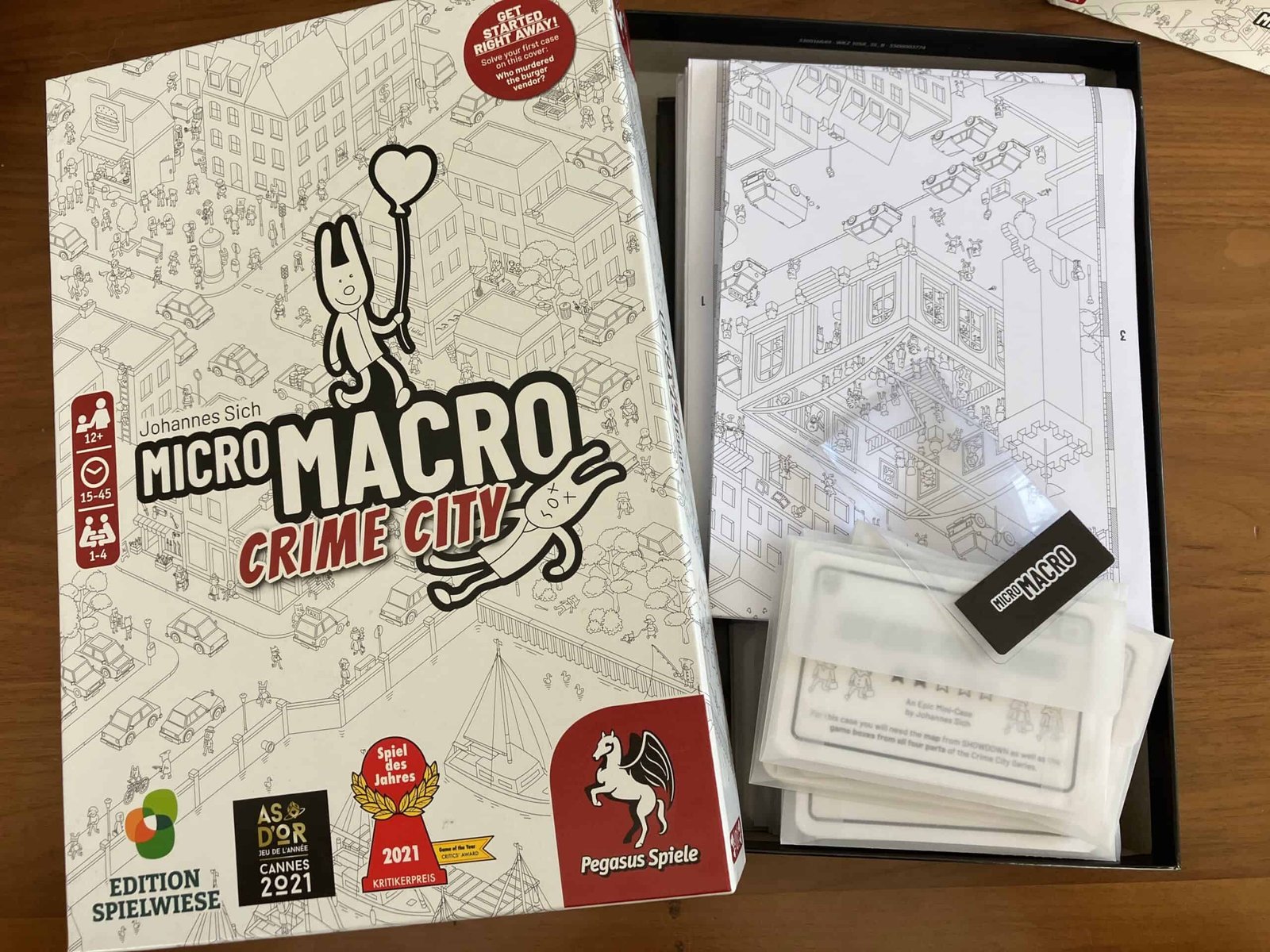 box containing a stack of cases, a map, and a magnifying glass